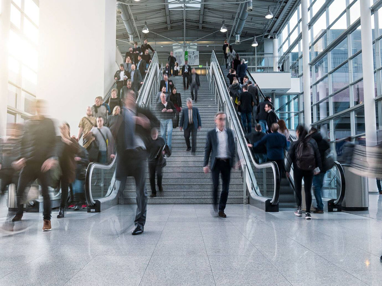 Motion-blur image of people using the escalator in a commercial space